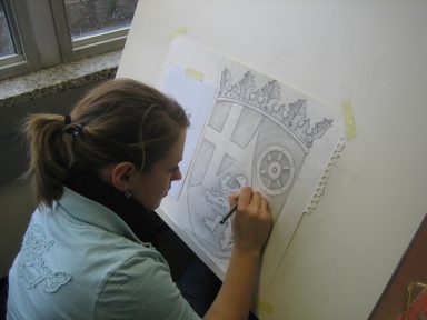 Kathrin post-Isenberg zeichnet an einer Zeichentafel.