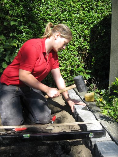 Kathrin Post-Isenberg arbeitet auf dem Friedhof und verlegt Steingräber.