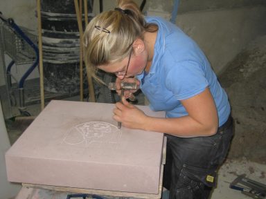 Kathrin post-Isenberg arbeitet mit Hammer und meißel.